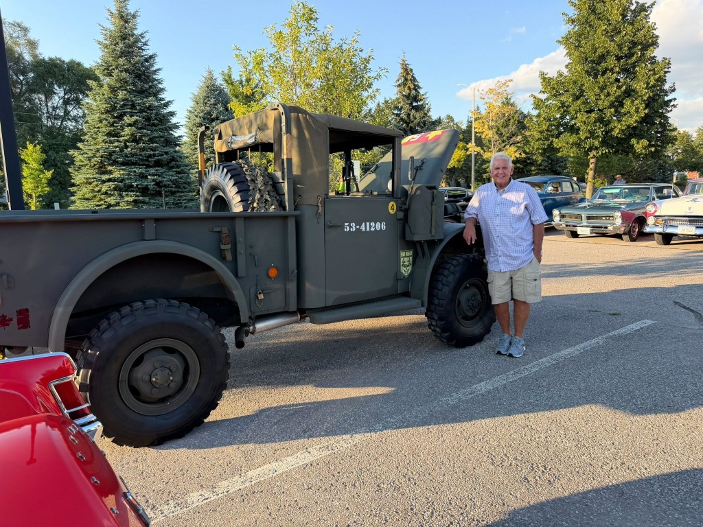 Wide view of classic cars and the army truck on display at the show