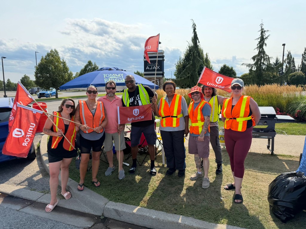 Dave Westlake and Unifor picketers on the crosswalk with union flags